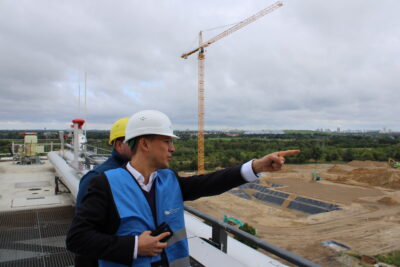 Benedikt Lux zeigt auf die Baustelle am Klärwerk Waßmannsdorf